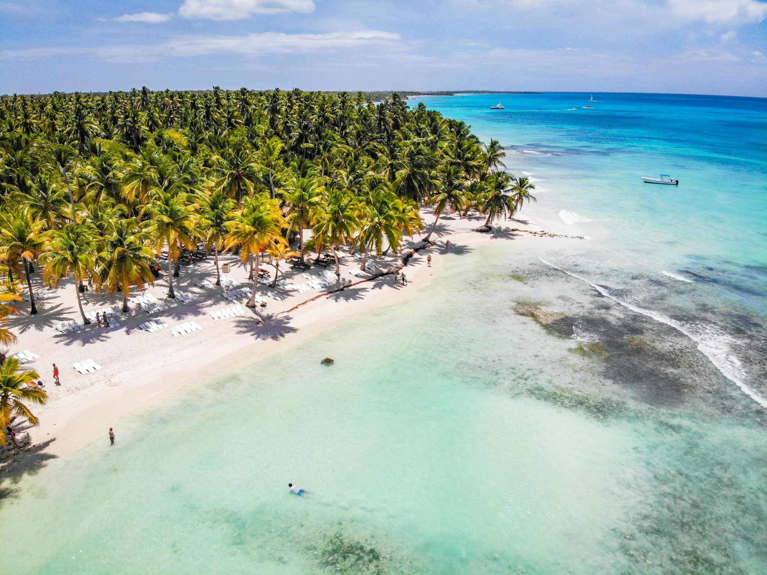 Vista aérea de playa tropical en Punta Cana, República Dominicana, con aguas turquesa y palmeras, destino clave para inversión inmobiliaria internacional a largo plazo.