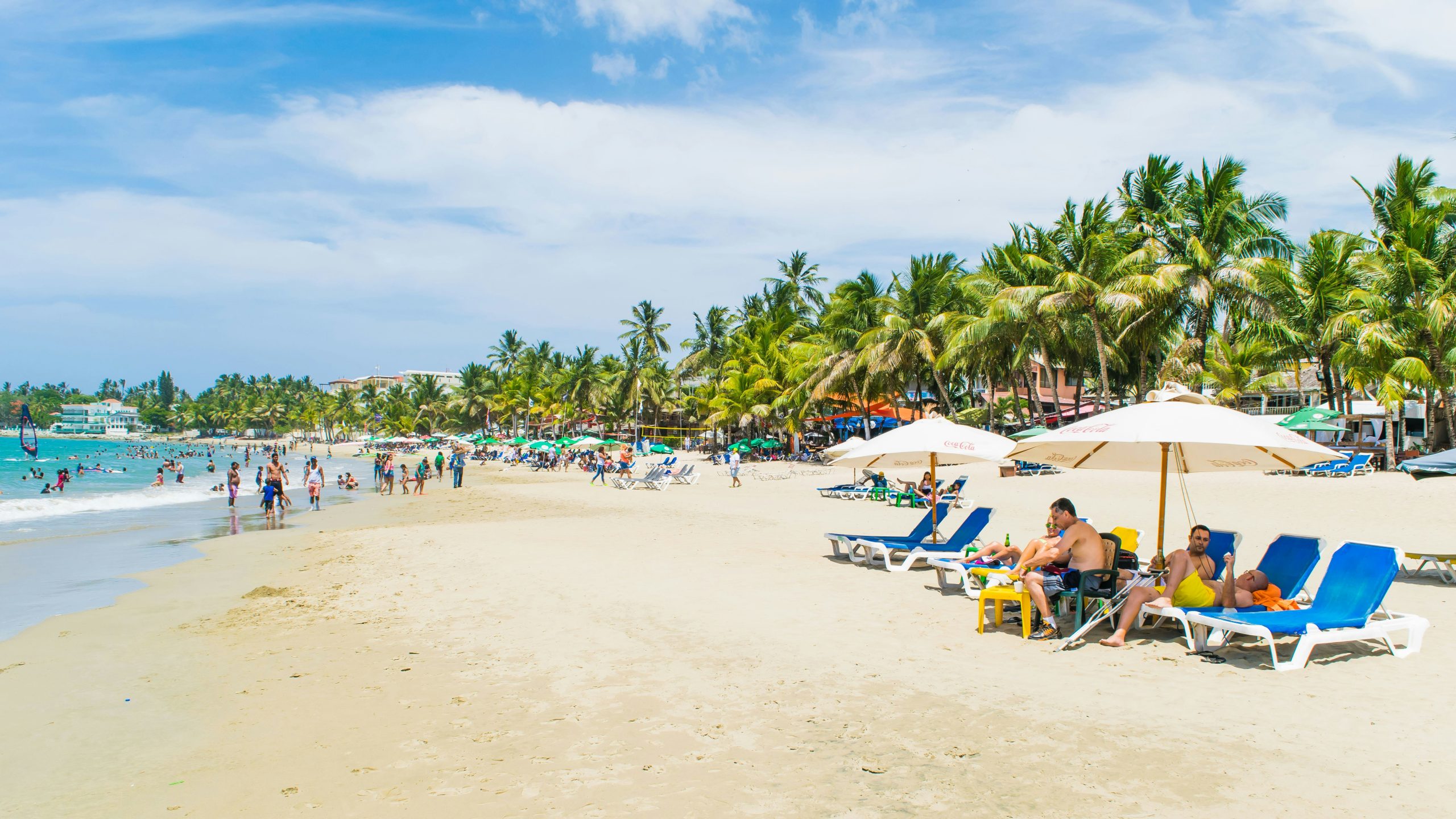 Playa de Punta Cana con turistas, palmeras y servicios frente al mar, reflejo del atractivo turístico y la alta demanda inmobiliaria.