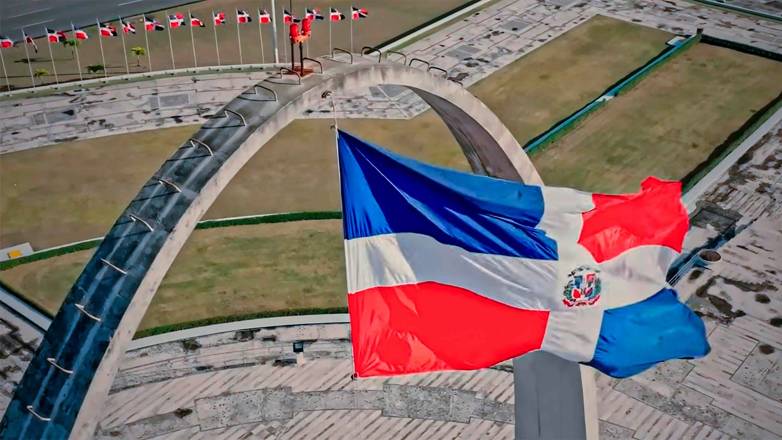 Bandera de la República Dominicana frente al Monumento a los Héroes de la Restauración en Santiago