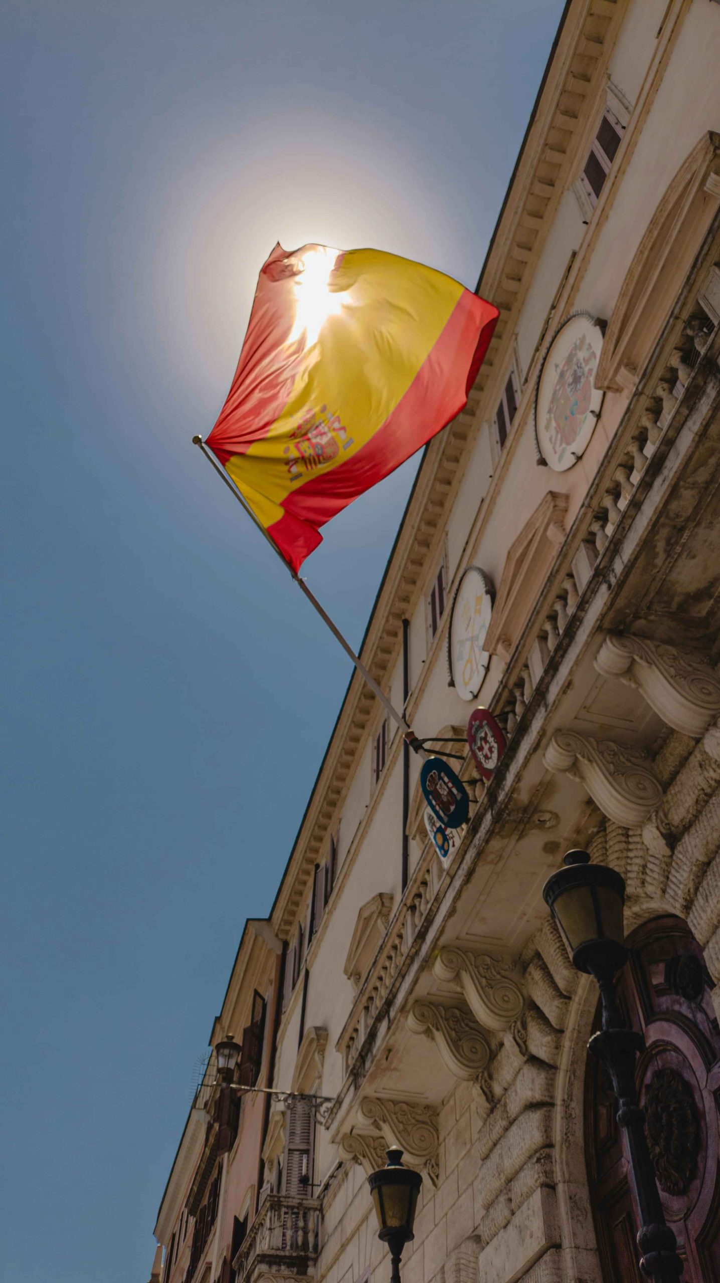 Bandera de España en contexto urbano representando el dinamismo del mercado inmobiliario español y el interés de inversores europeos en diversificar su patrimonio